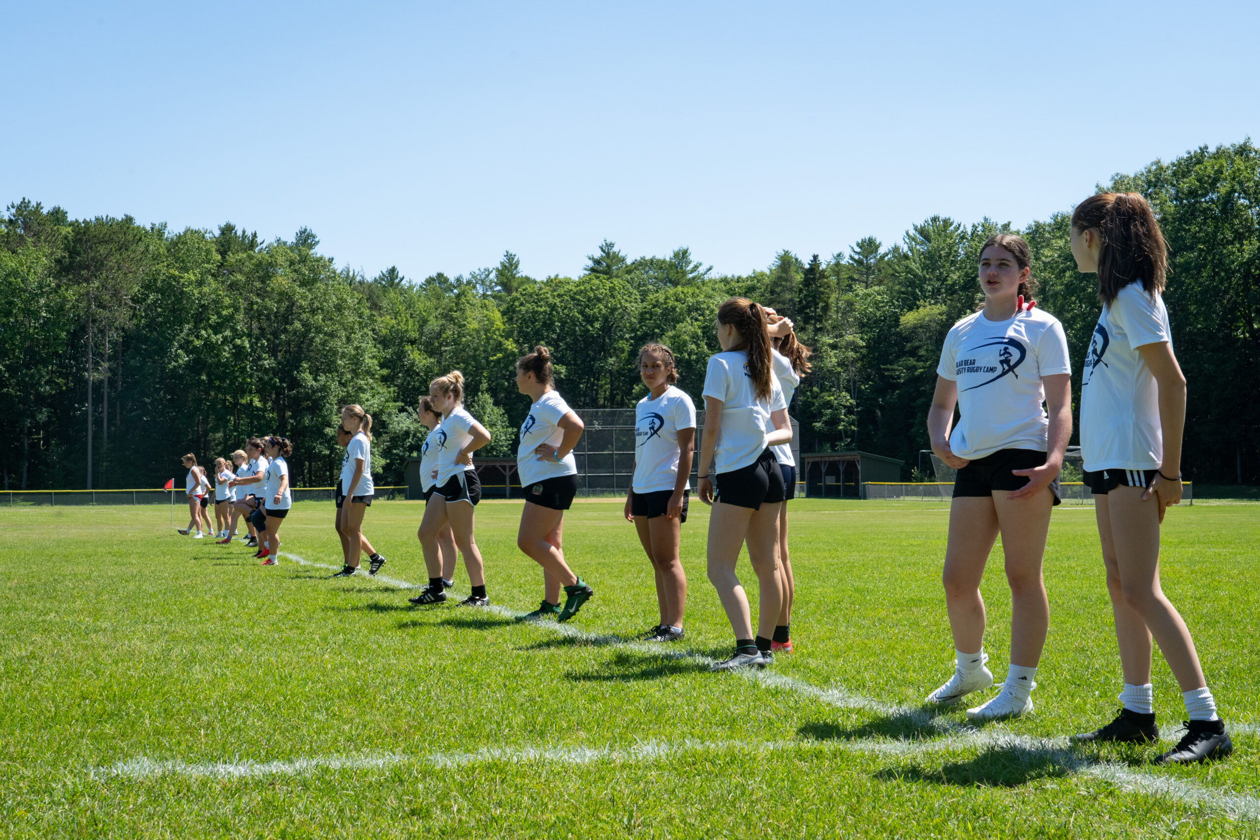 Students in a line warming up on a field